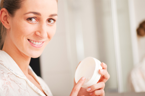 Woman applying facial lotion