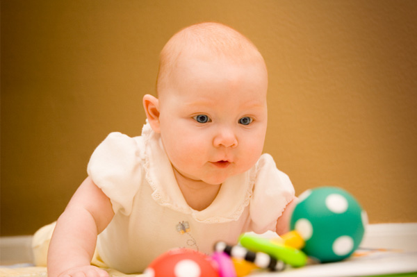 Baby crawling towards rattle