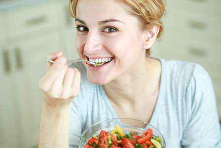 Happy woman eating DASH diet meal