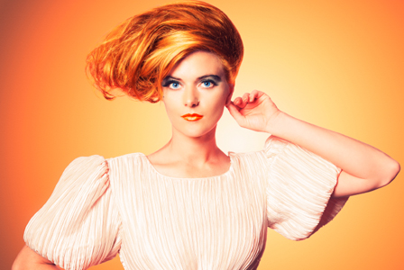Woman in nude colored clothing wearing neon makeup