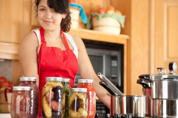 Woman canning vegetables at home