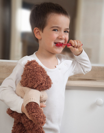 Happy little boy brushing teeth