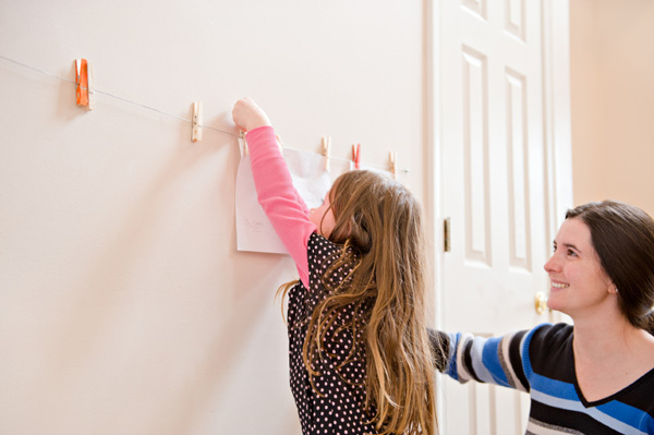 Little girl hanging artwork