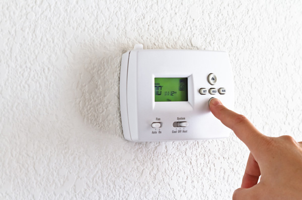 person adjusting thermostat