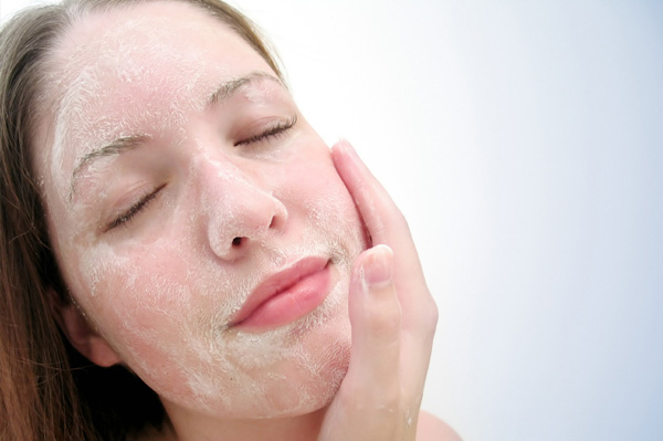 woman exfoliating her face