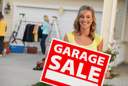 Woman holding garage sale sign