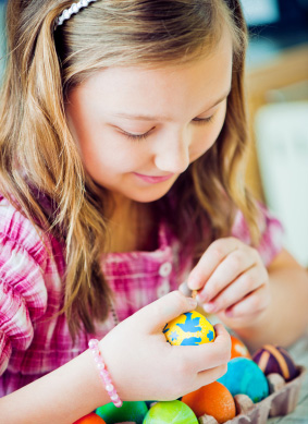 Girl coloring Easter Eggs