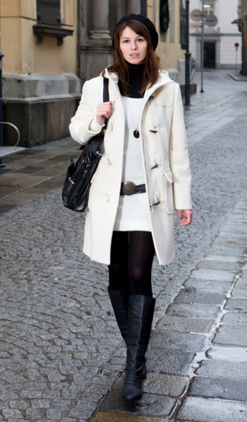 Woman wearing boots and a white coat