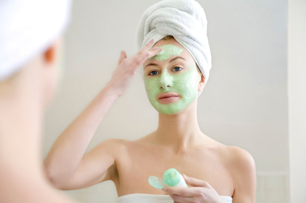 Woman applying a clay mask