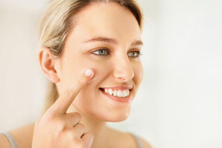 Woman applying tinted moisturizer