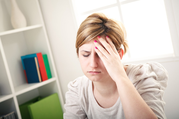 Woman with headache at home