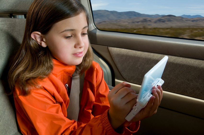 girl on roadtrip playing gameboy
