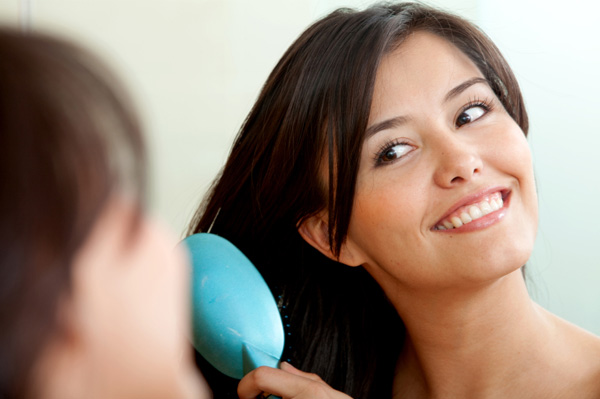 Woman brushing her hair in the mirror