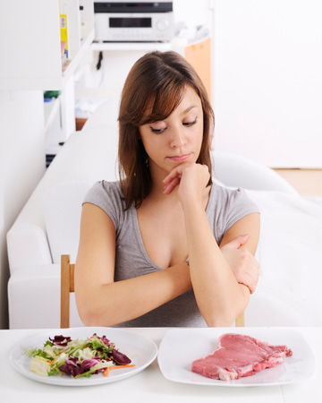 Woman choosing between meat and salad