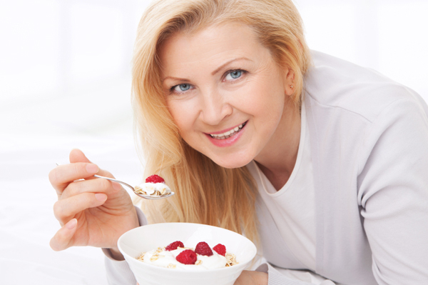 Woman eating yogurt and berries