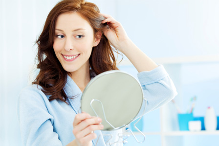 Woman looking at her hair in the mirror