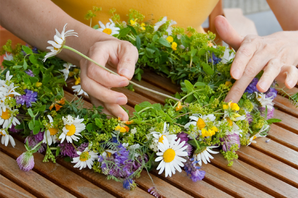 woman creating wreath with flowers