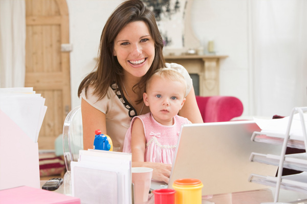 mom working on laptop with toddler