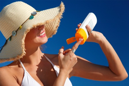 Woman applying sunscreen at the beach