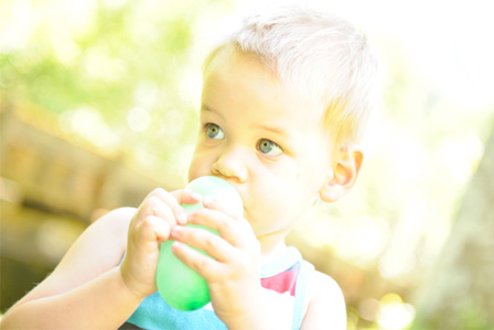 Little boy blowing up balloon