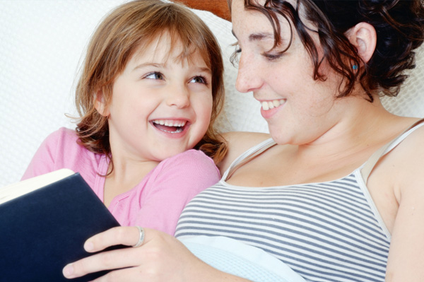 mom reading chapter book with daughter