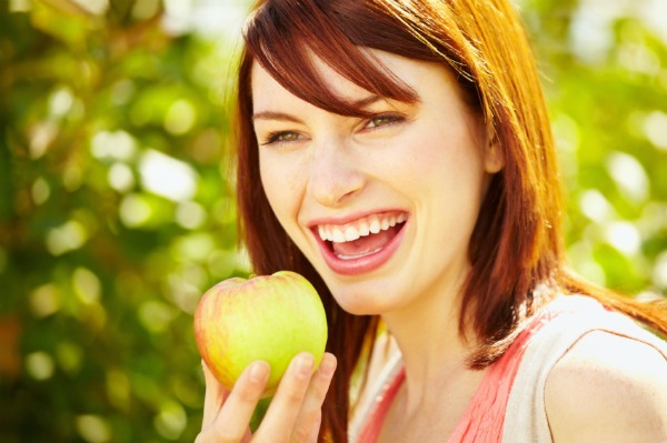 woman snacking on apple