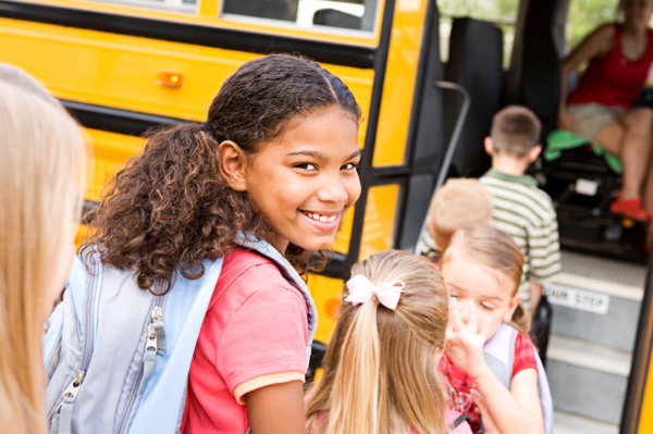 girl getting on school bus