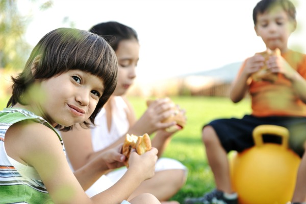 kid eating sandwich outside