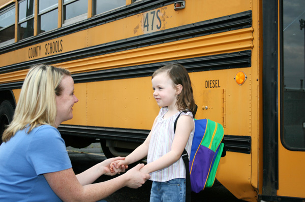 Mom putting daughter on the bus
