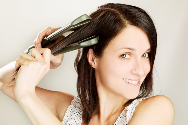 Woman straightening her hair