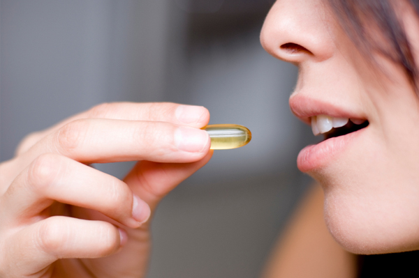 Woman taking supplements for healthy hair