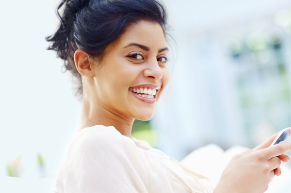 smiling woman typing on smartphone