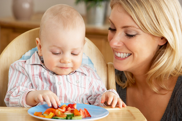 Mother feeding toddler son