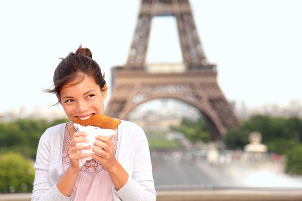 Woman eating in front of Eiffel Tower