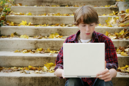 Boy on the computer outdoors