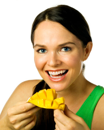 Happy woman eating mango
