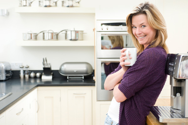 Woman relaxing in organized kitchen
