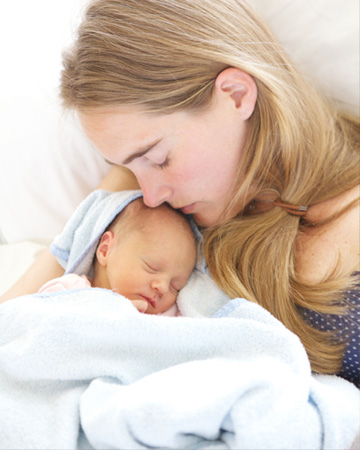 mom cuddling with newborn baby