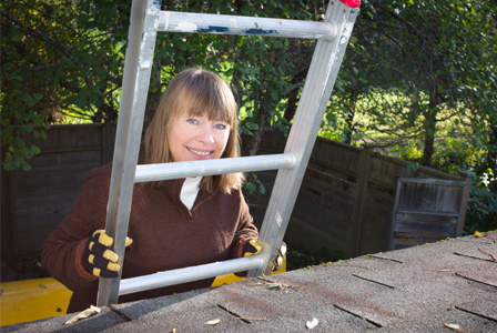 Woman cleaning gutters