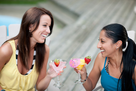 Women having cocktails by the pool