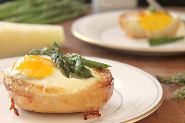 Baked eggs in bread bowls with cheese and asparagus