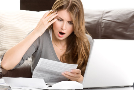 Shocked woman looking at bills