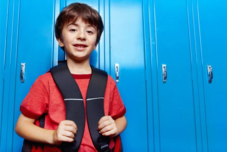 Boy in school with backpack