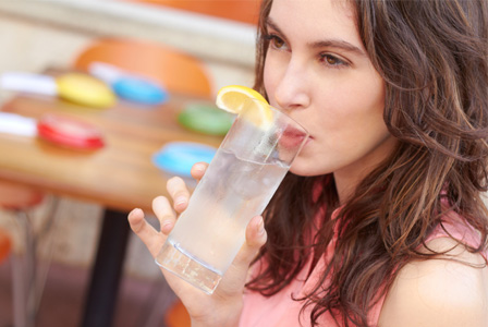 Woman drinking water with lemon