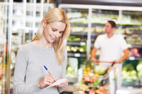 Woman with shopping list in grocery store