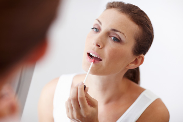 Woman applying lip gloss
