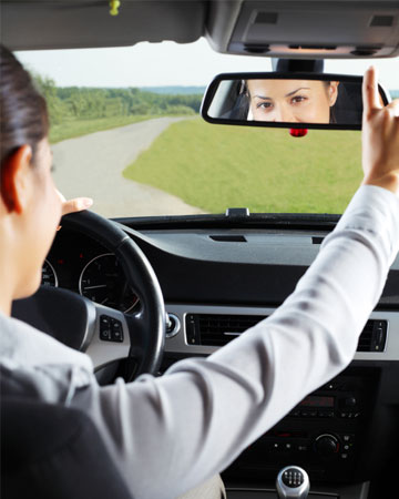 Woman adjusting rearview mirror