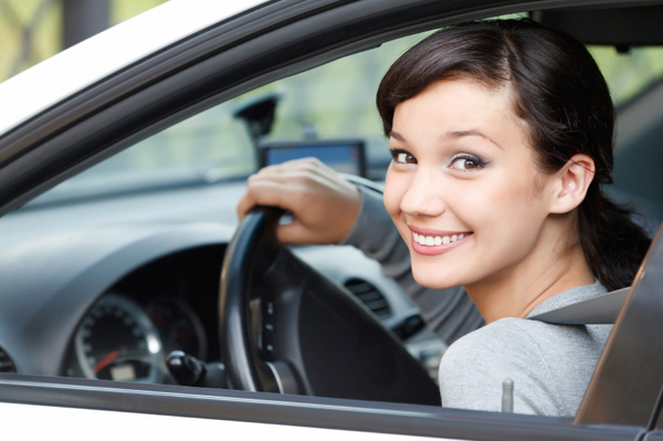 Smiling and confident young woman sitting in car