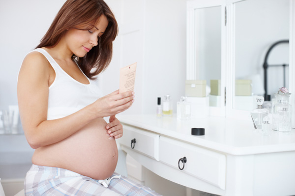 Woman putting lotion on stomach