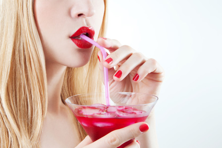 Woman drinking red cocktail